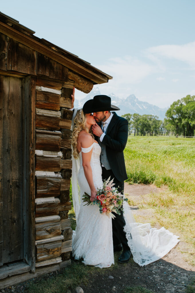 Historic Mormon Row barn in Grand Teton National Park with wide open fields and Teton peaks in the background — rustic Wyoming elopement location.