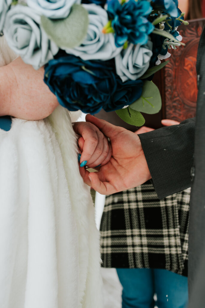 Couple exchanging vows beside snowy creek during intimate Jackson Hole elopement