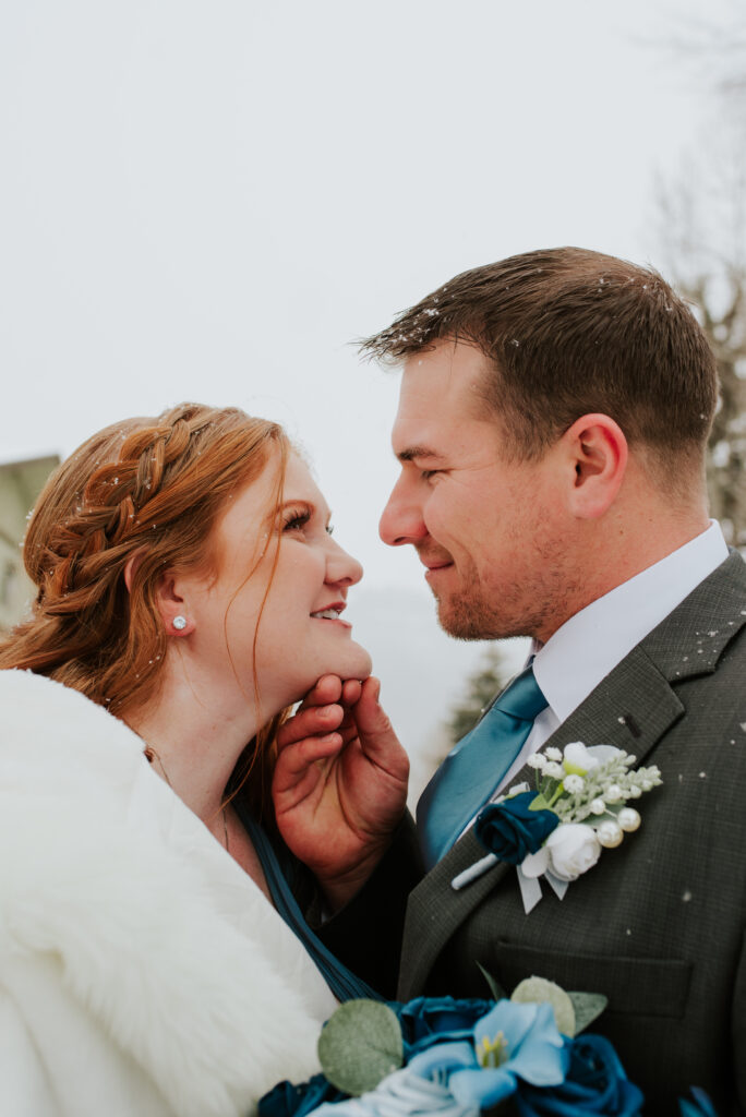 Bride and groom looking at each other snowy downtown Jackson, Wyoming