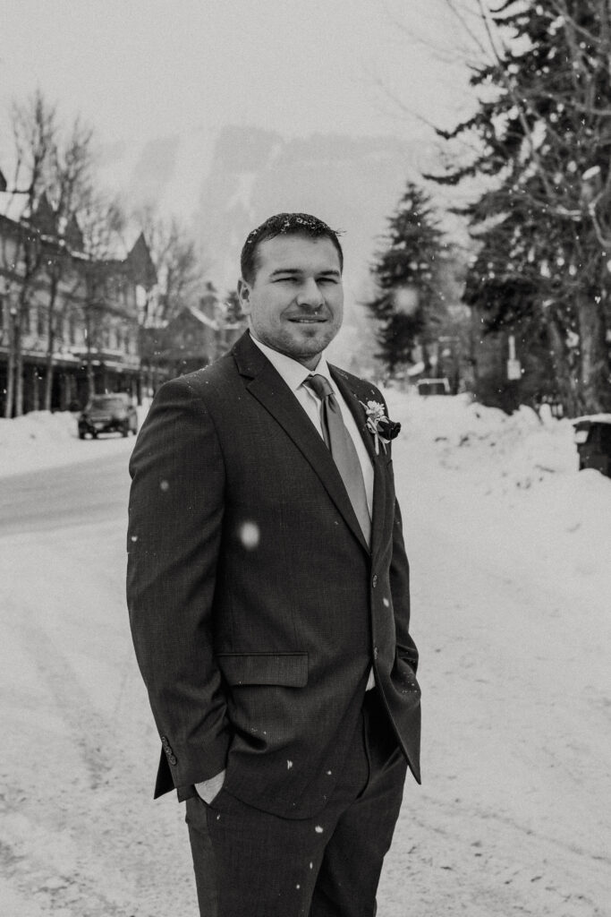 Winter elopement groom portraits in downtown Jackson Hole with snow-covered boardwalks