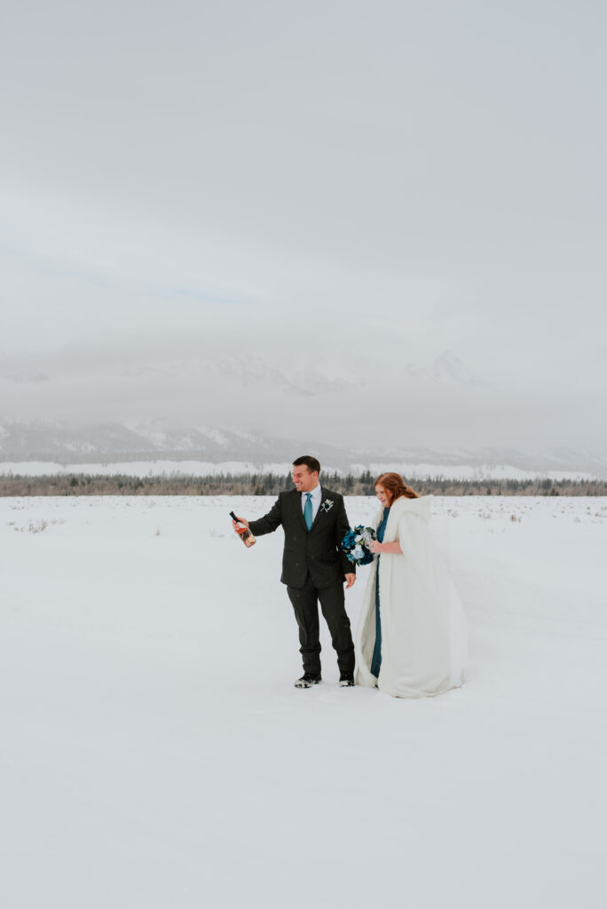 Couple popping champagne after elopement in the Grand Tetons