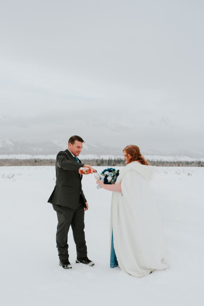 Couple embracing during a winter Jackson Hole elopement with snow-covered Tetons in the background