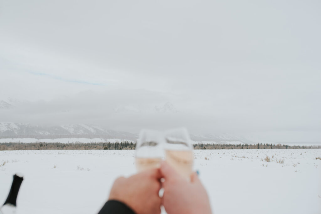 Bride and groom walking through fresh snow during their Tetons winter elopement