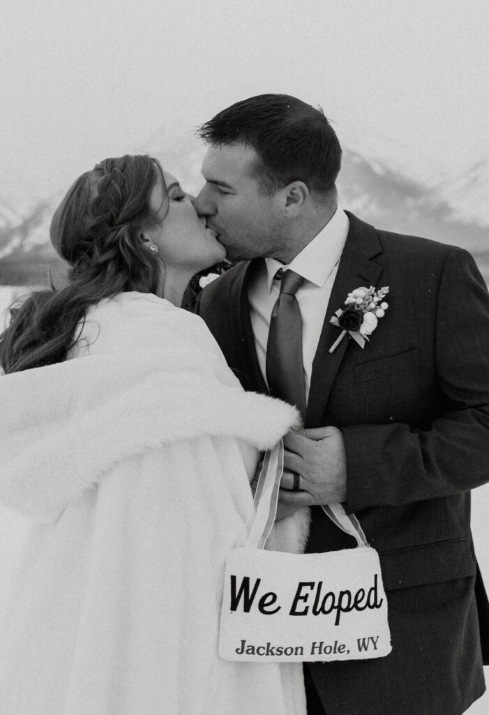 Couple embracing during a winter Jackson Hole elopement with snow-covered Tetons in the background