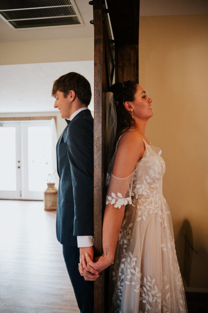 Emotional first touch at The Barn on 1st wedding in Idaho Falls captured with timeless photography